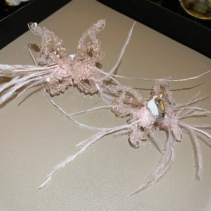 Macro shot of pink beaded butterfly ear clips with soft feathers and gold metal base