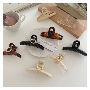 Flat lay of colorful French style geometric hair claws on a white surface with props