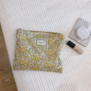 Detailed close-up of yellow floral cotton makeup bag with Time to Party fabric label