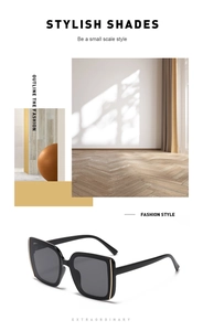 Detail view of retro oversized square sunglasses with black frames and dark gray lenses