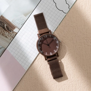 Détail d'une montre à quartz marron chocolat avec bracelet maille et trotteuse cœur