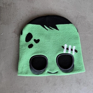 Detailed knit texture of green Halloween Frankenstein beanie with stitched face embroidery