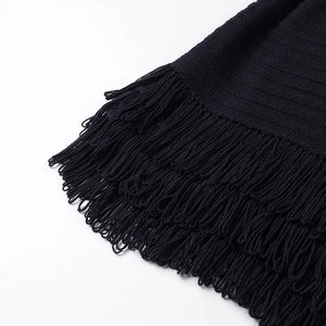 Detailed view of dense fringe edges and fine knit texture on long sleeve jacket