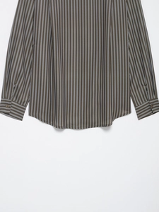 Detail of vertical brown striped poplin shirt showing curved hem and buttoned cuffs
