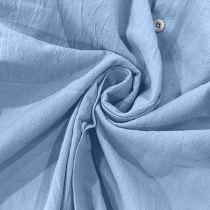 Macro detail of light blue cotton linen fabric texture and buttons on a men's shirt