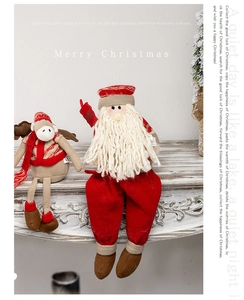 Detailed view of plush Santa and Reindeer dolls sitting on a white festive fireplace