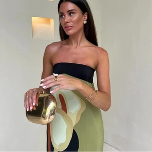 Detail of gold mirror clutch bag paired with avocado print tube dress and metal jewelry