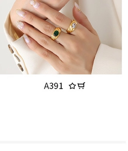 Close-up of gold rings with green and white gemstone inlays worn with a white suit