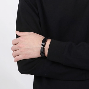 Dettaglio di un bracciale da uomo in pelle intrecciata con chiusura magnetica
