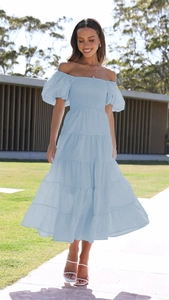 Detail of light blue off-shoulder maxi dress featuring puff sleeves and tiered skirt texture