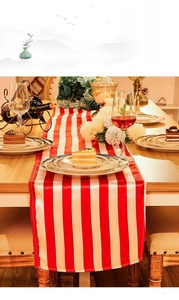 Detail of red and white striped table runner with smooth texture on a dining table