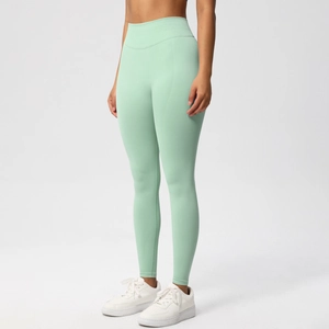 Detail view of mint green high-waisted seamless yoga pants with peach butt lifting texture