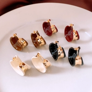Detail view of 18k gold plated enamel C-shaped hoop earrings in four assorted colors