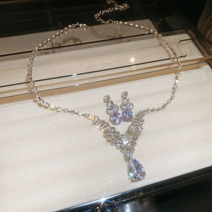 Détail du parure collier et boucles d'oreilles argentées avec cristaux violets en poire