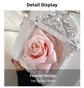 Close-up of Baroque embossed frame with a 3D pink rose and pearl chain on white bag