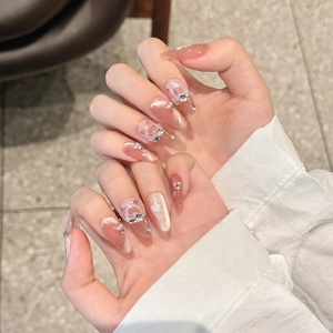 Cat eye press-on nails with pink heart accents and pearl charms in stiletto shape