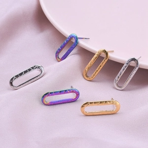 Macro view of geometric stainless steel earrings with textured finish in three metal tones
