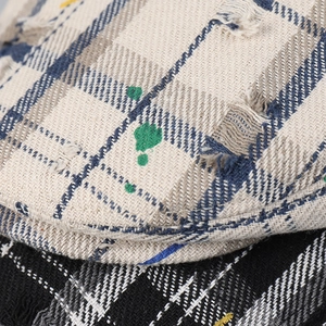 Vintage distressed plaid beret hat with artistic graffiti and frayed edge details