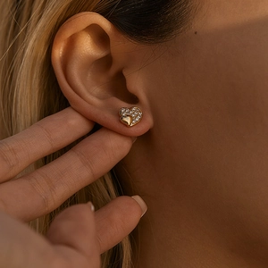 Detailed view of heart-shaped earrings with sparkling cubic zirconia on gold metal