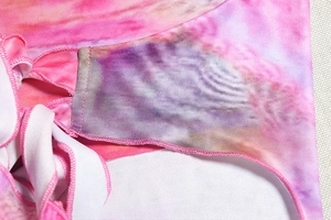 Close-up of fine stitching and pink gradient tie-dye pattern on the cropped top fabric
