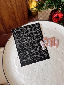 Detailed view of Christmas nail stickers with white bell motifs and festive 3D snowflake nails