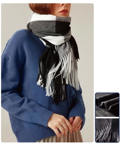 Close-up of classic black and white plaid scarf with fringe tassels for winter warmth