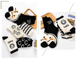 Detail of cotton crew socks with smile face and stripe patterns in a cozy setting