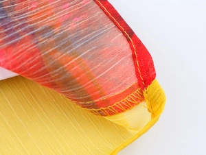 Detail of floral chiffon shirt showing delicate yellow hem stitching and sheer red fabric