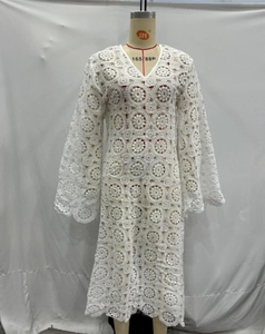 Detail of white crochet lace maxi dress featuring intricate floral embroidery and V-neckline