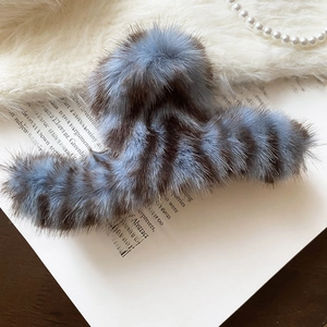 Macro detail of blue and brown striped faux fur hair claw on elegant vintage background