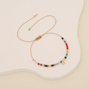 Close-up of bohemian beaded bracelet with colorful stones and sparkling crystal charm