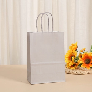 White kraft paper gift bag with twisted handles and sunflower decor on beige table
