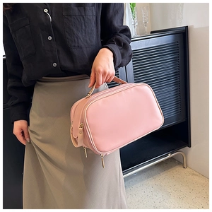 Close-up of pink nylon makeup bag with double-layer metal zippers and handle detail