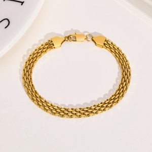 Detail of 18K gold mesh chain bracelet showing triple-row weave and lobster clasp
