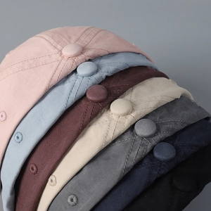 Detailopname van de pet met bijpassende knoop en geborduurde ventilatieopeningen