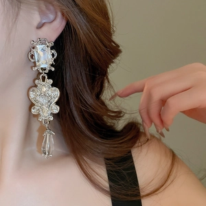 Detail of luxury teardrop floral resin earrings with rhinestones on a female model