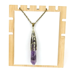 Macro detail of purple amethyst hexagonal crystal point with vintage bronze metal cap