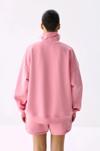 Vue arrière du sweat rose à demi-zip et du short assorti sur un mannequin pro