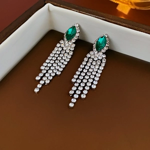 Nahaufnahme grüner Tropfensteine mit langen glitzernden Strass-Quasten an silbernen Ohrringen