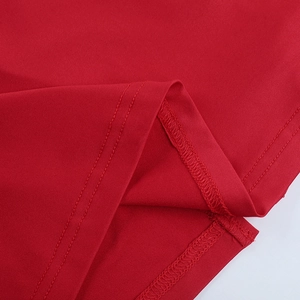 Vue macro des coutures à double aiguille et détails de l'ourlet de la robe rouge