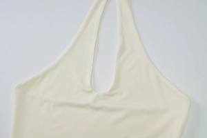 Detail of cream halter top neck design and high-stretch ribbed knit fabric texture