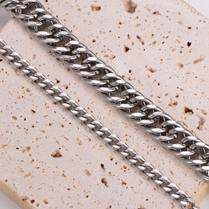 Dual-size 11mm and 5mm silver curb chain bracelets for men shown on a textured stone