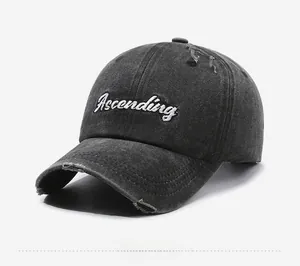 Detail view of the distressed washed denim cap with white Ascending cursive embroidery