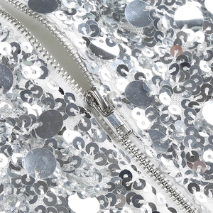 Detailed macro view of silver sequins and metal zipper on this elegant party dress