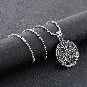 Detailed close-up of a silver Thor's Hammer Mjolnir pendant with Nordic runes