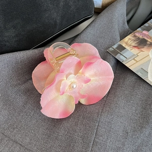 Close-up of orchid hair claw clip with pink gradient petals and white pearl accent
