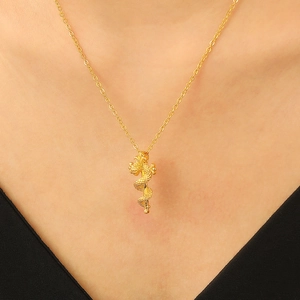 Elegant gold snake scepter pendant necklace worn by a model on a black V-neck top