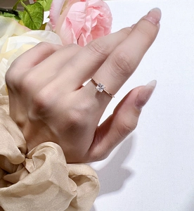 Close-up of Asscher cut moissanite ring in S925 silver on finger with silk and rose
