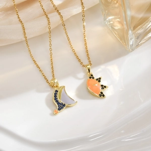 Detailed shot of 18k gold plated sun and moon pendants with colorful enamel on satin background