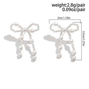 Detailed view of pearl bow earrings showing 3.5cm height and 3cm width dimensions